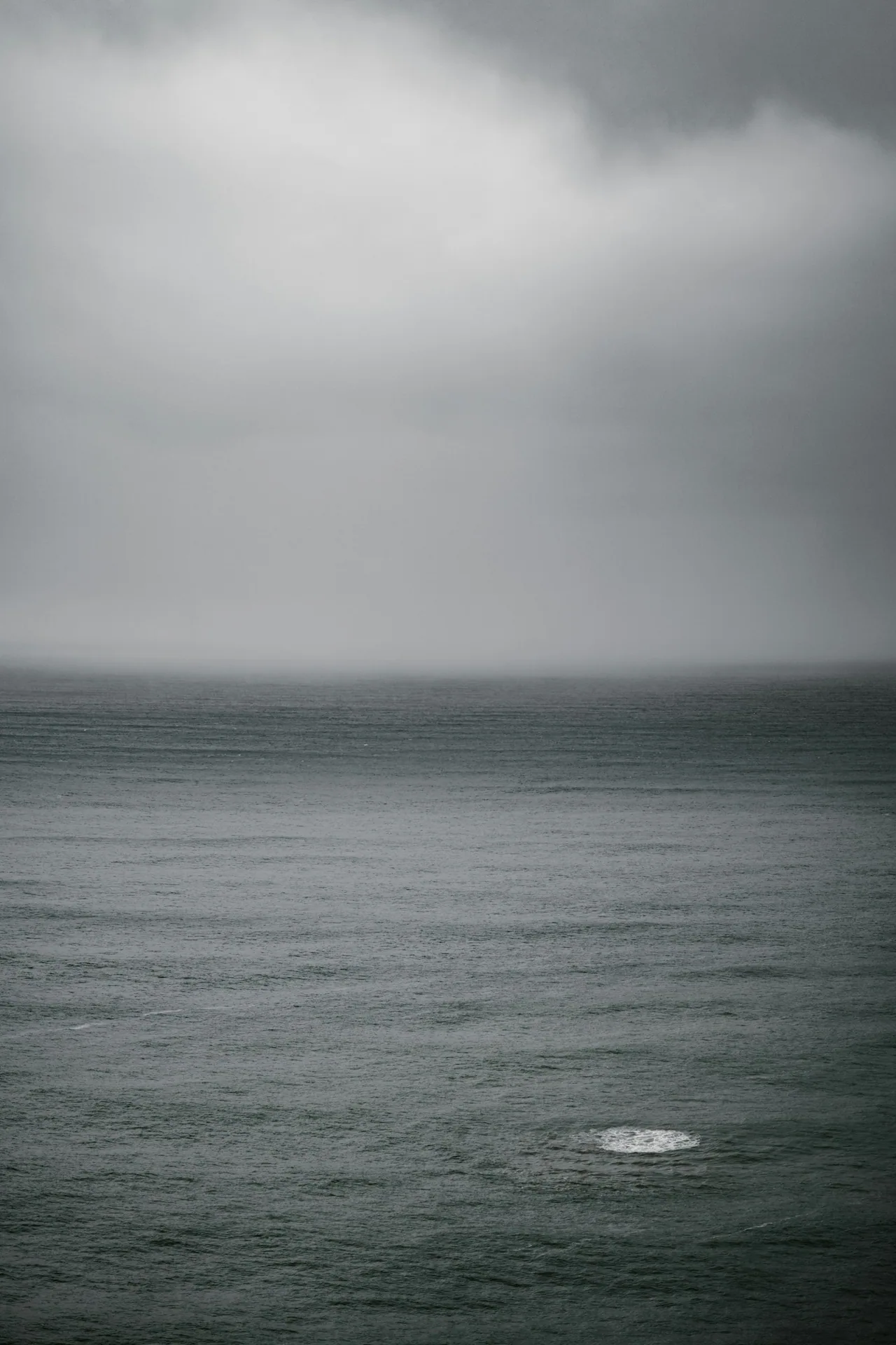 Grey ocean beneath dense layers of storm cloud.